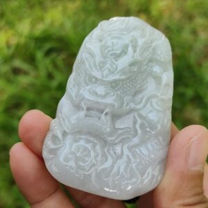 a hand holding a carved stone