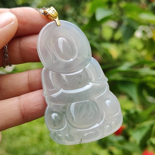 a hand holding a jade pendant