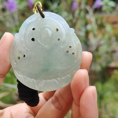 एक हाथ में जेड पेंडेंट थामे हुए