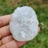 Una mano sosteniendo un colgante de jade.
