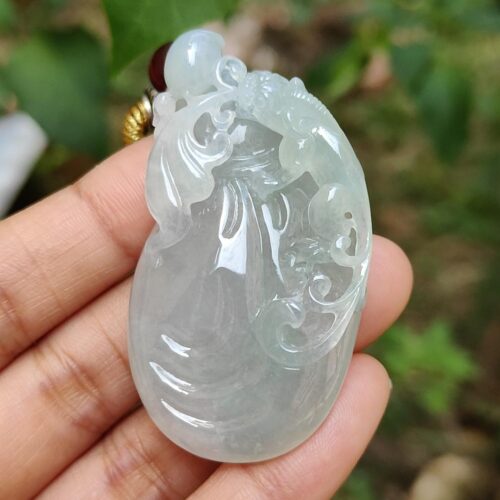Una mano sosteniendo un colgante de jade.