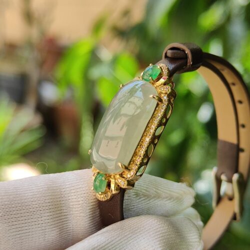 a hand in glove holding a bracelet