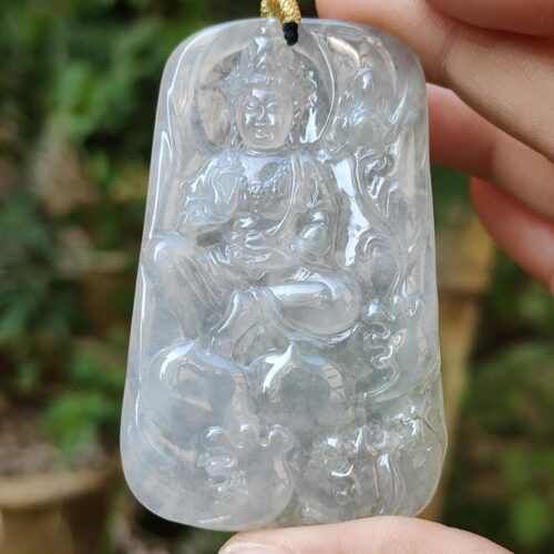 a hand holding a jade pendant