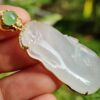 a hand holding a jade pendant