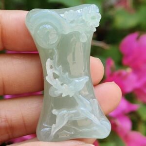 a hand holding a jade object