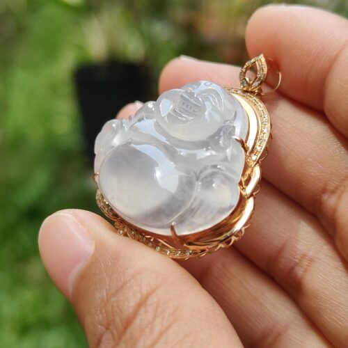 a hand holding a jade pendant