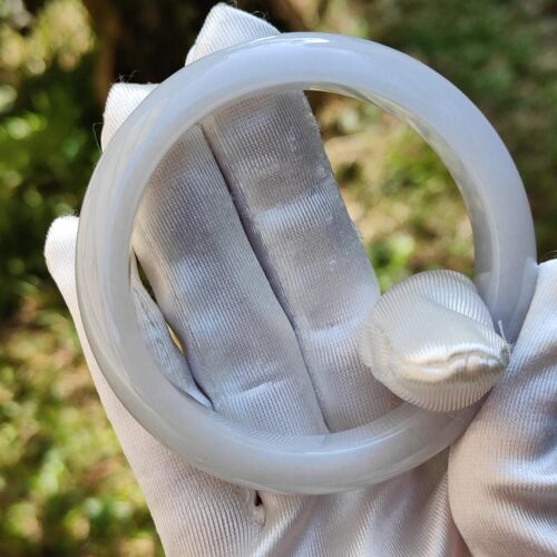 a gloved hand holding a white ring