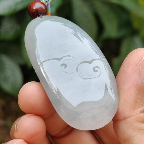 a hand holding a jade pendant