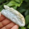 a hand holding a jade carving