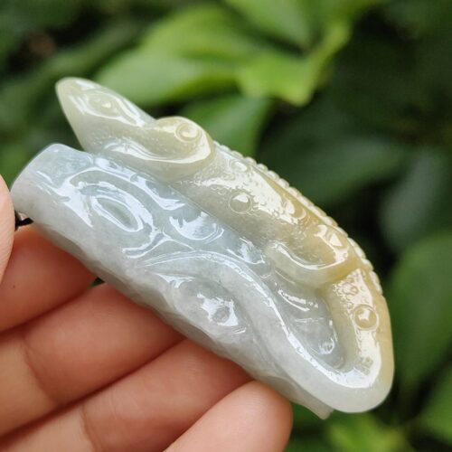 a hand holding a jade carving