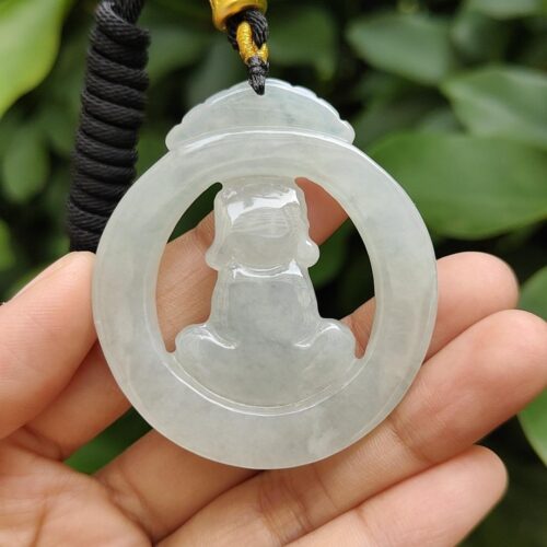 a hand holding a jade pendant