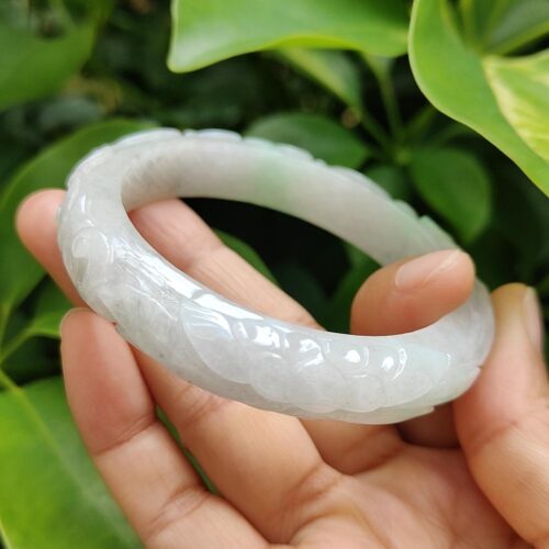 a hand holding a white bracelet