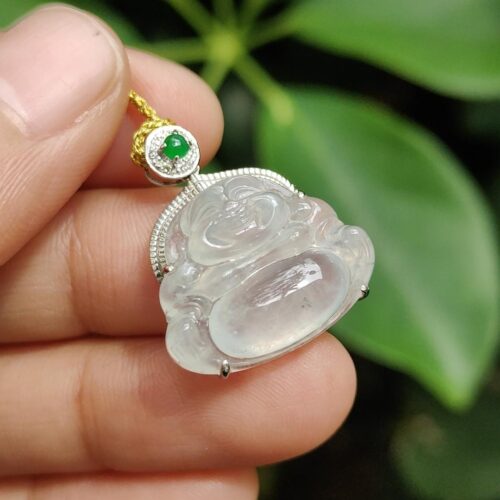 tangan memegang liontin giok