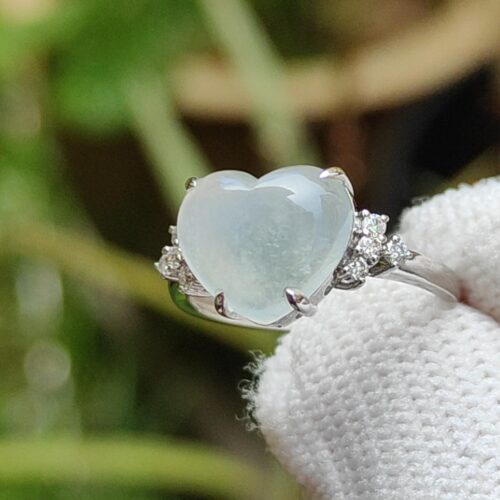 a hand wearing a white glove with a heart shaped ring