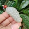 a hand holding a white bead