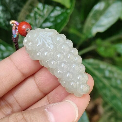 a hand holding a white bead