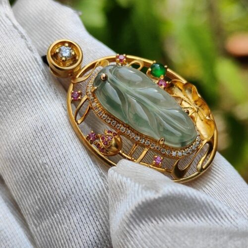 a gold ring with a green stone and gemstone