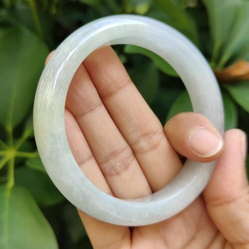 a hand holding a round white ring