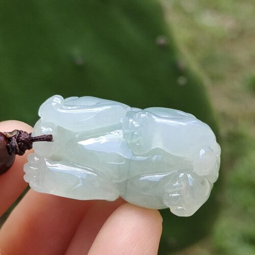 a hand holding a jade sculpture