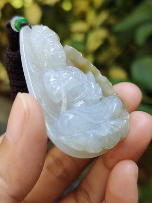 a hand holding a jade pendant
