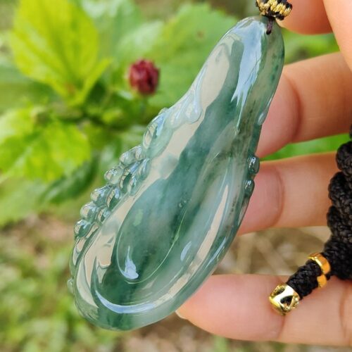 uma mão segurando um colar de jade