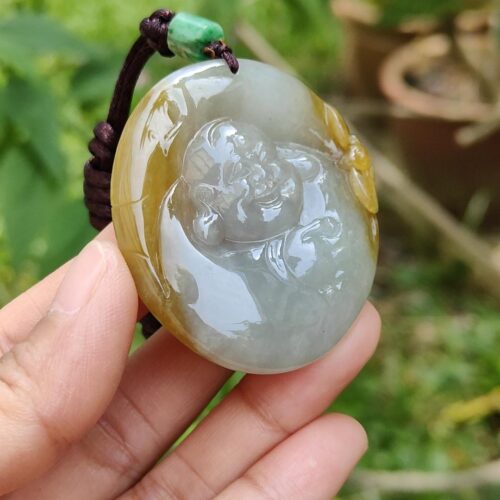 a hand holding a jade pendant