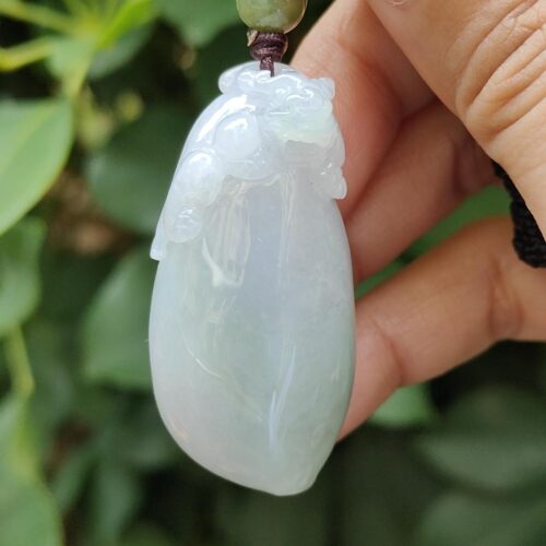 ஜேட் பதக்கத்தை வைத்திருக்கும் ஒரு கை