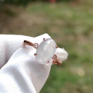 a hand wearing a white glove with a ring