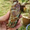 a hand holding a stone pendant