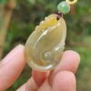 Una mano sosteniendo un colgante de jade.