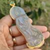 Una mano sosteniendo un colgante de jade.