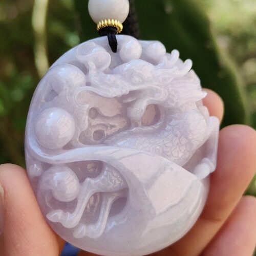 Una mano sosteniendo un colgante de jade.