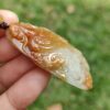 Una mano sosteniendo un colgante de jade.