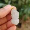 Una mano sosteniendo un colgante de jade.