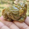 a hand holding a small green stone