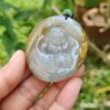 a hand holding a jade pendant