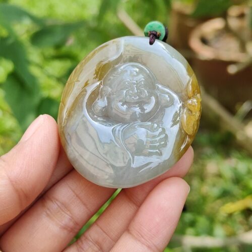 a hand holding a jade pendant