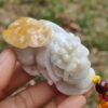 a hand holding a small white stone figure