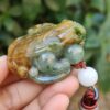 a hand holding a jade frog