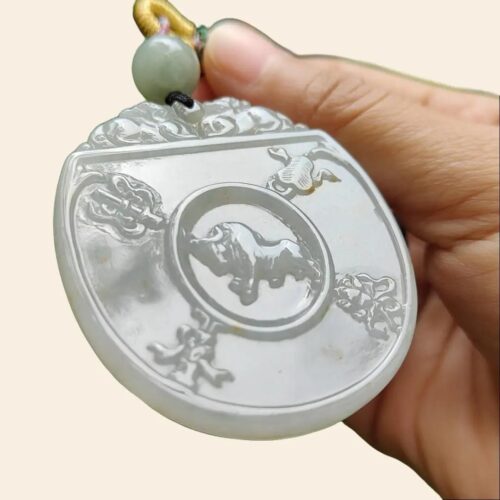 une main tenant un pendentif