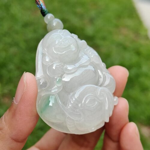 a hand holding a jade pendant
