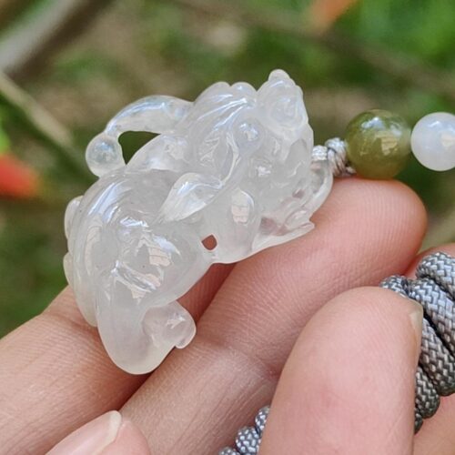 Una mano sosteniendo un colgante de jade.