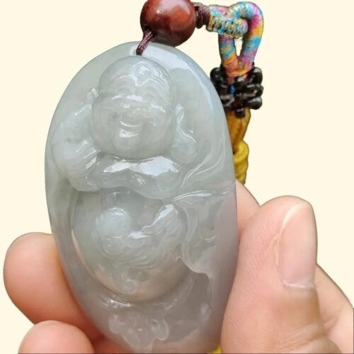 a hand holding a jade pendant