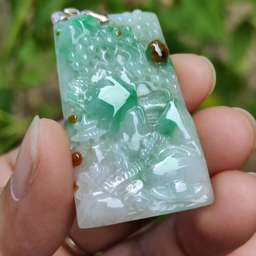 a hand holding a jade object
