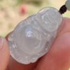 a hand holding a jade pendant
