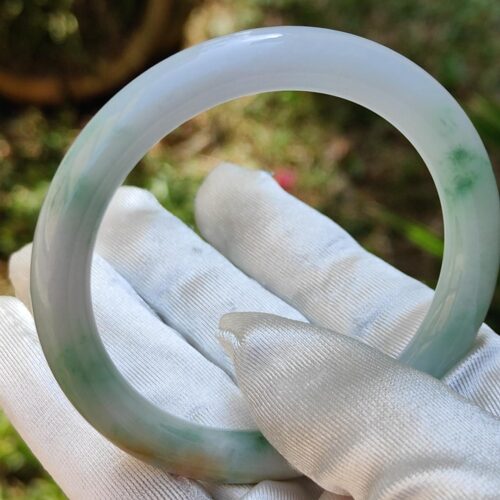 a hand in white glove holding a circular object