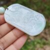 Una mano sosteniendo un colgante de jade.