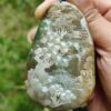 a hand holding a stone pendant