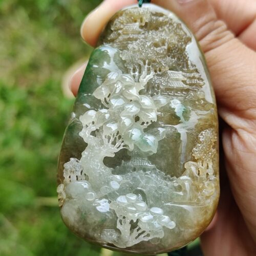 a hand holding a stone pendant
