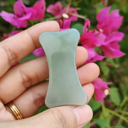 a hand holding a jade stone